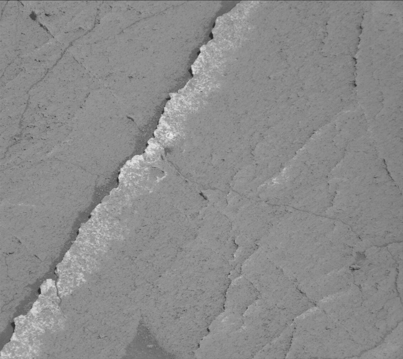 This is a black and white zoomed in image of the rocky, sandy surface of Mars.