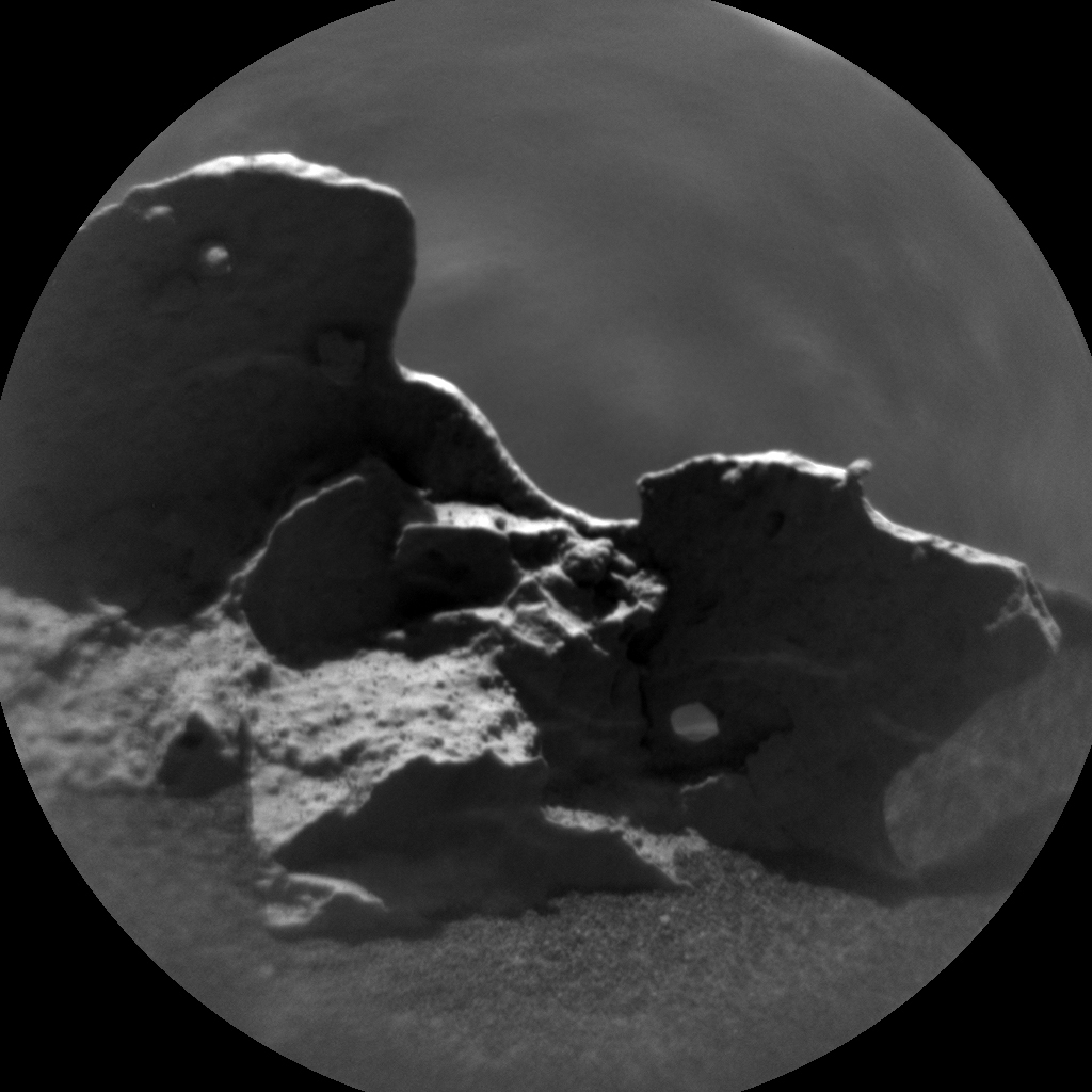 This is a black and white image of a dark clouds with few light clouds in the background taken by the Curiosity rover on Mars.