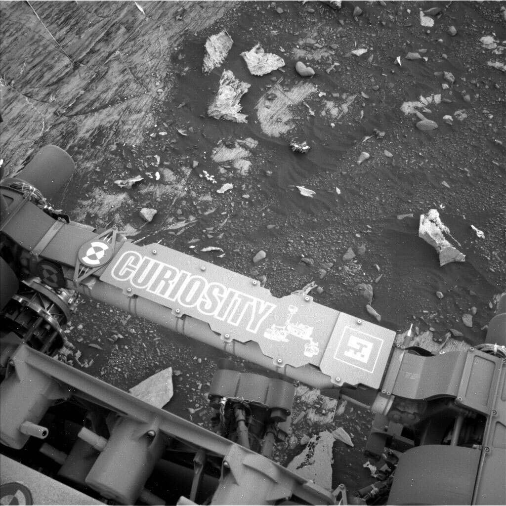 This is a black and white image of the sandy, rocky surface of Mars.