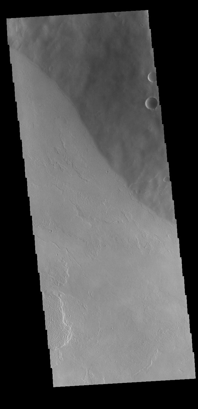 This image from NASAs Mars Odyssey shows the flank of Tharsis Tholus. The Tharsis region of Mars is dominated by large volcanoes and extensive lava plains.