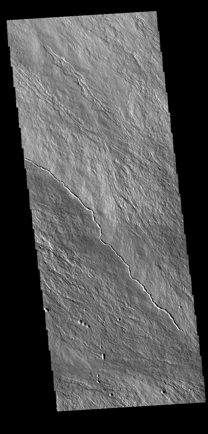 This image from NASAs Mars Odyssey shows the upper slopes of Olympus Mons. Numerous thin lava flows are visible.