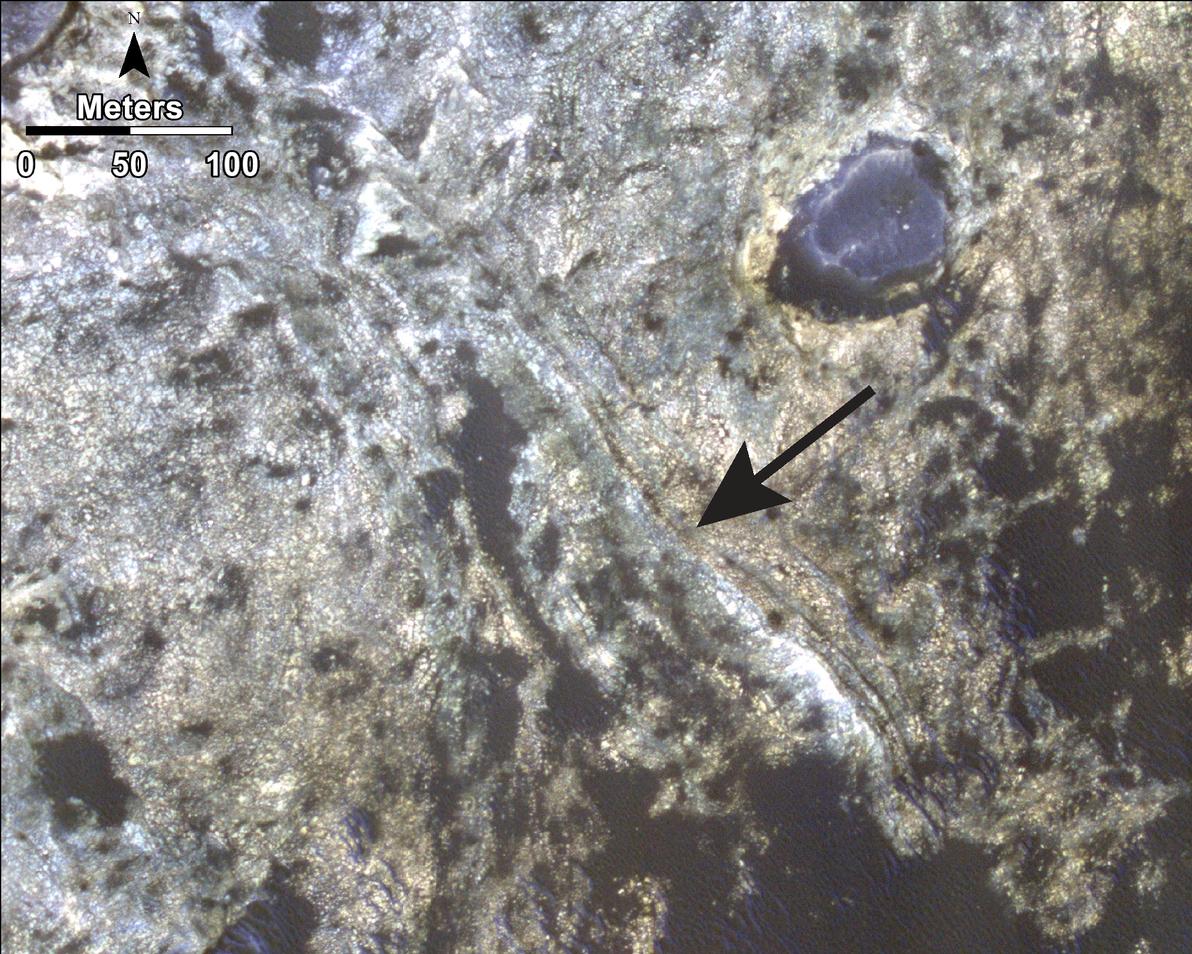 This image shows distinct bands of alternating tone and brightness within the "Murray Formation" on Mars. A black arrow points to those bands, which cut across diagonally in this image.
