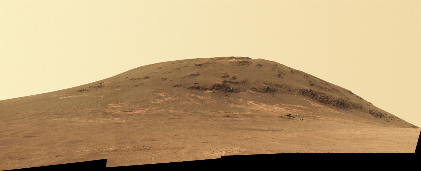 Wheel tracks from NASA's Mars rover Opportunity descending and departing the "Cape Tribulation" segment of Endeavour Crater's rim are visible in this April 21, 2017, view from the rover's Panoramic Camera (Pancam). The rover looked back northward during its trek south to "Perseverance Valley."