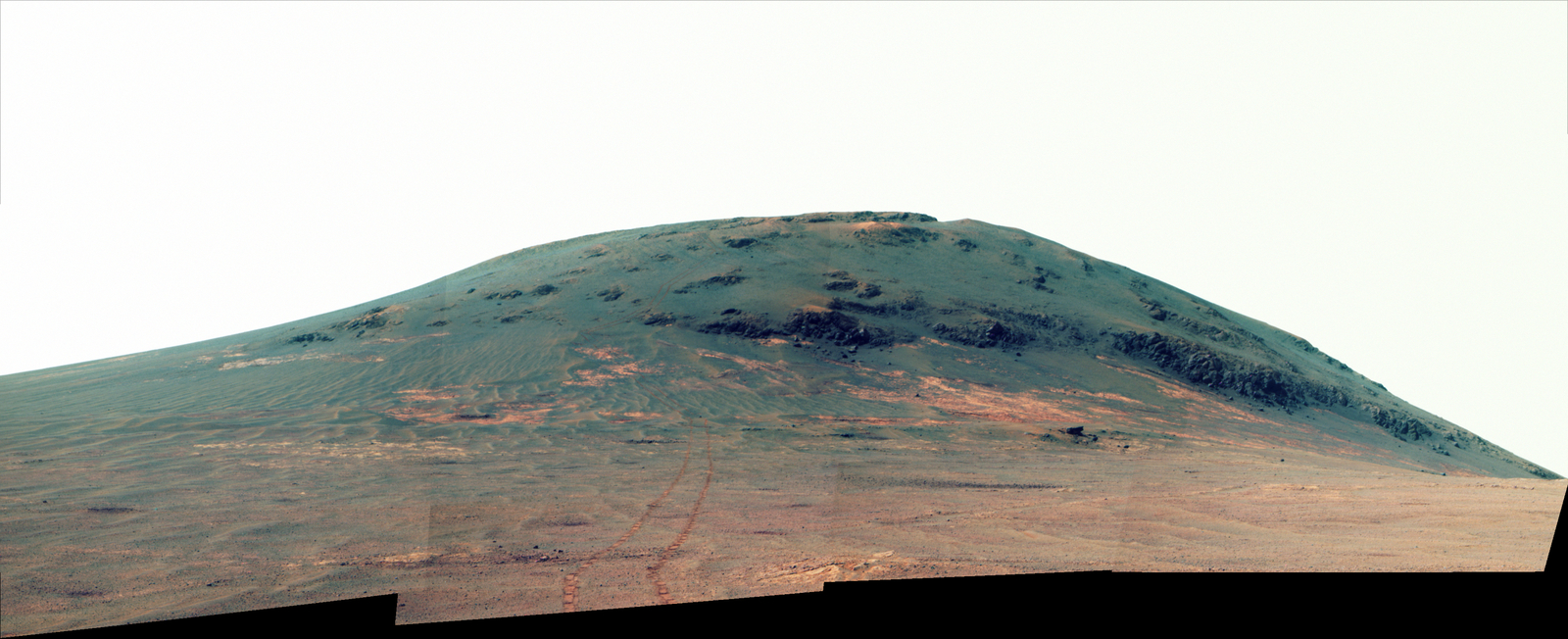 Wheel tracks from NASA's Mars rover Opportunity descending and departing the "Cape Tribulation" segment of Endeavour Crater's rim are visible in this April 21, 2017, view from the rover's Pancam. This version is presented in enhanced color to make differences in surface materials more visible.